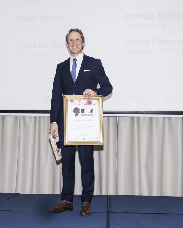 En mann som holder et sertifikat