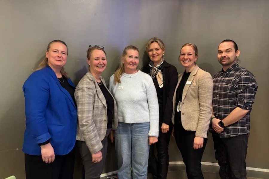 En gruppe mennesker i arbeidspakke 14 som poserer for et bilde